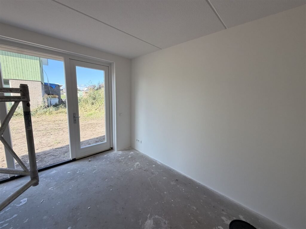 Nieuwbouwkamer met tuindeuren, kort na het behangen van de wanden