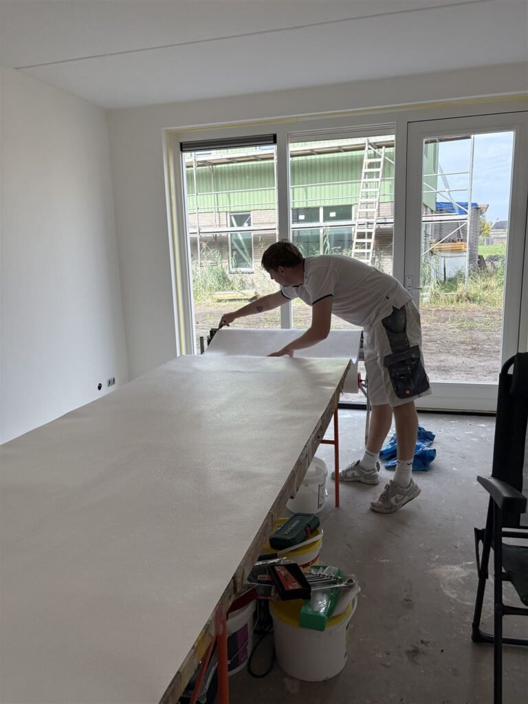 Behanger aan de plaktafel in een nieuwbouwwoonkamer met grote raampartij
