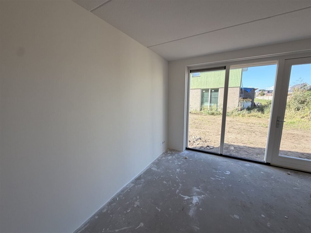Nieuwbouwwoonkamer met tuindeuren en egaal witte wanden